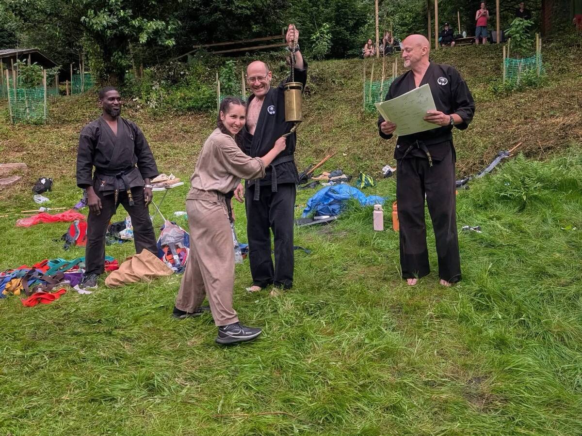 Carlotta ringing the DKK bell after grading for Shodan at the 2026 Summer Camp