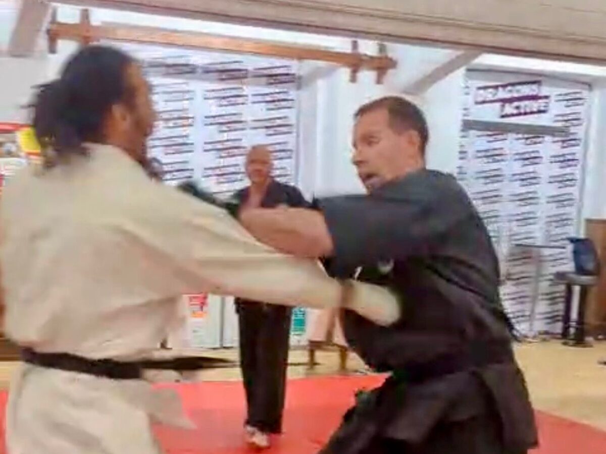 Mike Thornton in a close-range exchange with a partner in a white gi