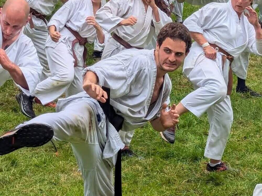 Sebastien front and centre in a low stance during kata at summer camp